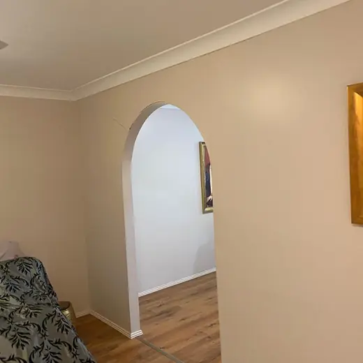 Hallway with an arched doorway and timber floors