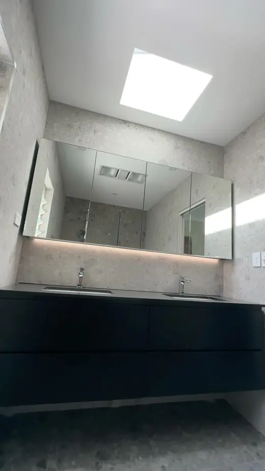 Renovated bathroom with a mirror cabinet and skylight