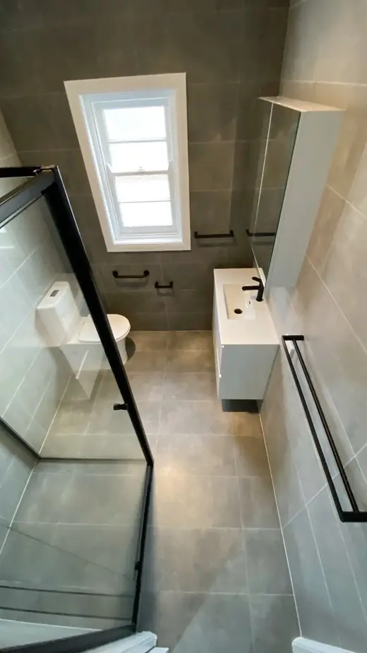 Renovated bathroom with a skylight and glass shower screen