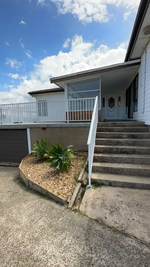Front steps with a handrail leading up to a home