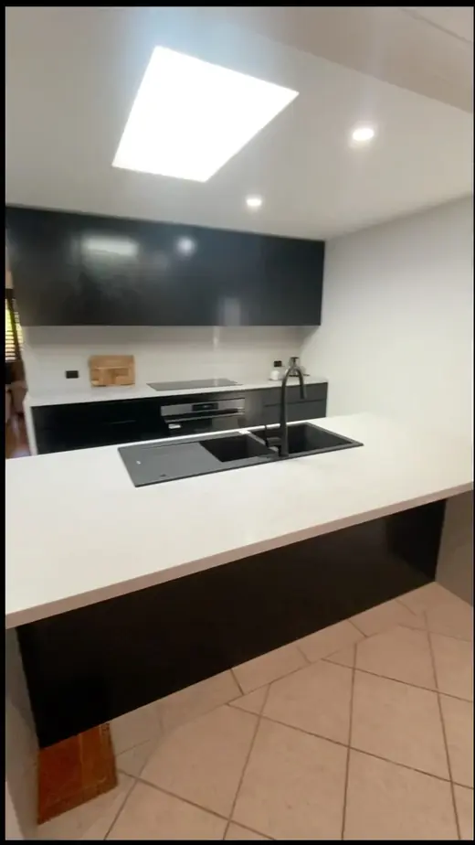 Renovated kitchen with black cabinets and a skylight