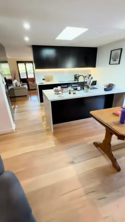 Renovated kitchen with a black island bench and timber floors