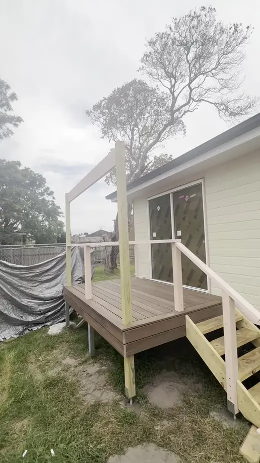 Small timber deck with white railing and steps
