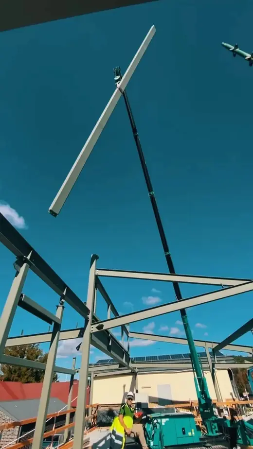 Steel frame structure being lifted into place by crane